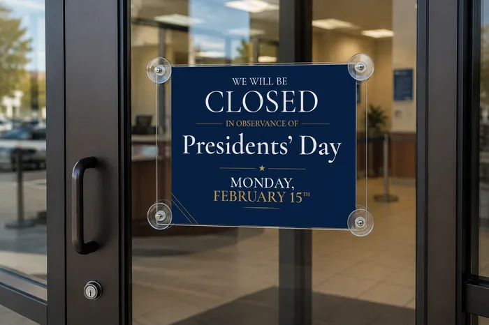 Presidents' Day sign displayed on a bank entrance glass door using a suction cup sign holder